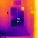 A thermal image of a room with a door.